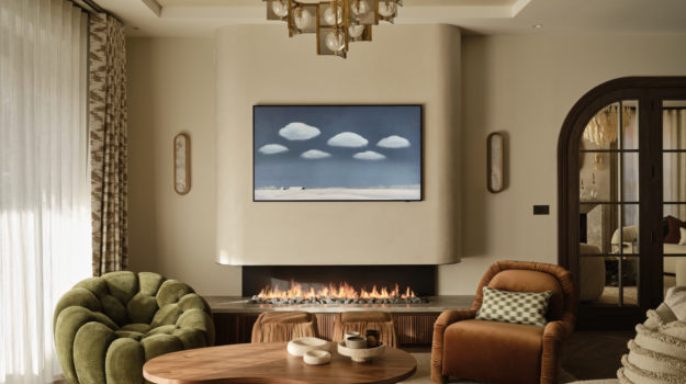 Bespoke linear gas fireplace with fluted oak base, stone surround, lava rock fuel bed and smooth curved plastered flue by Modus Fireplaces