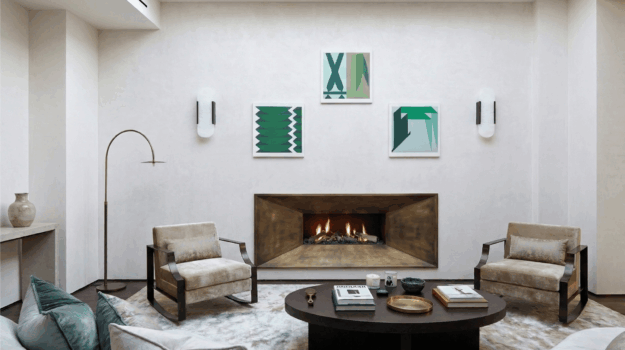 Bespoke gas fireplace with chamfered brushed bronze steel surround and log fuel bed in a contemporary plastered living room by Modus Fireplaces